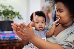 Mother and toddler smiling and clapping hands.