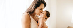 Mother holding a newborn baby at home.