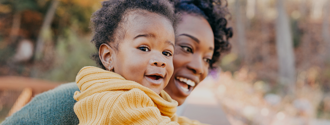 African American mother and child smile and look into the distance.