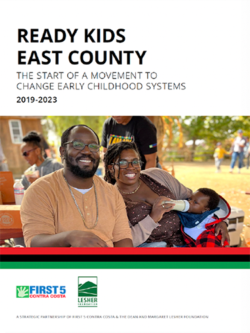Una familia sonriente —un hombre, una mujer y un niño— está sentada al aire libre. El niño bebe de un biberón. La imagen aparece en la portada de un informe titulado «Ready Kids East County: El inicio de un movimiento para cambiar los sistemas de la primera infancia 2019-2023».