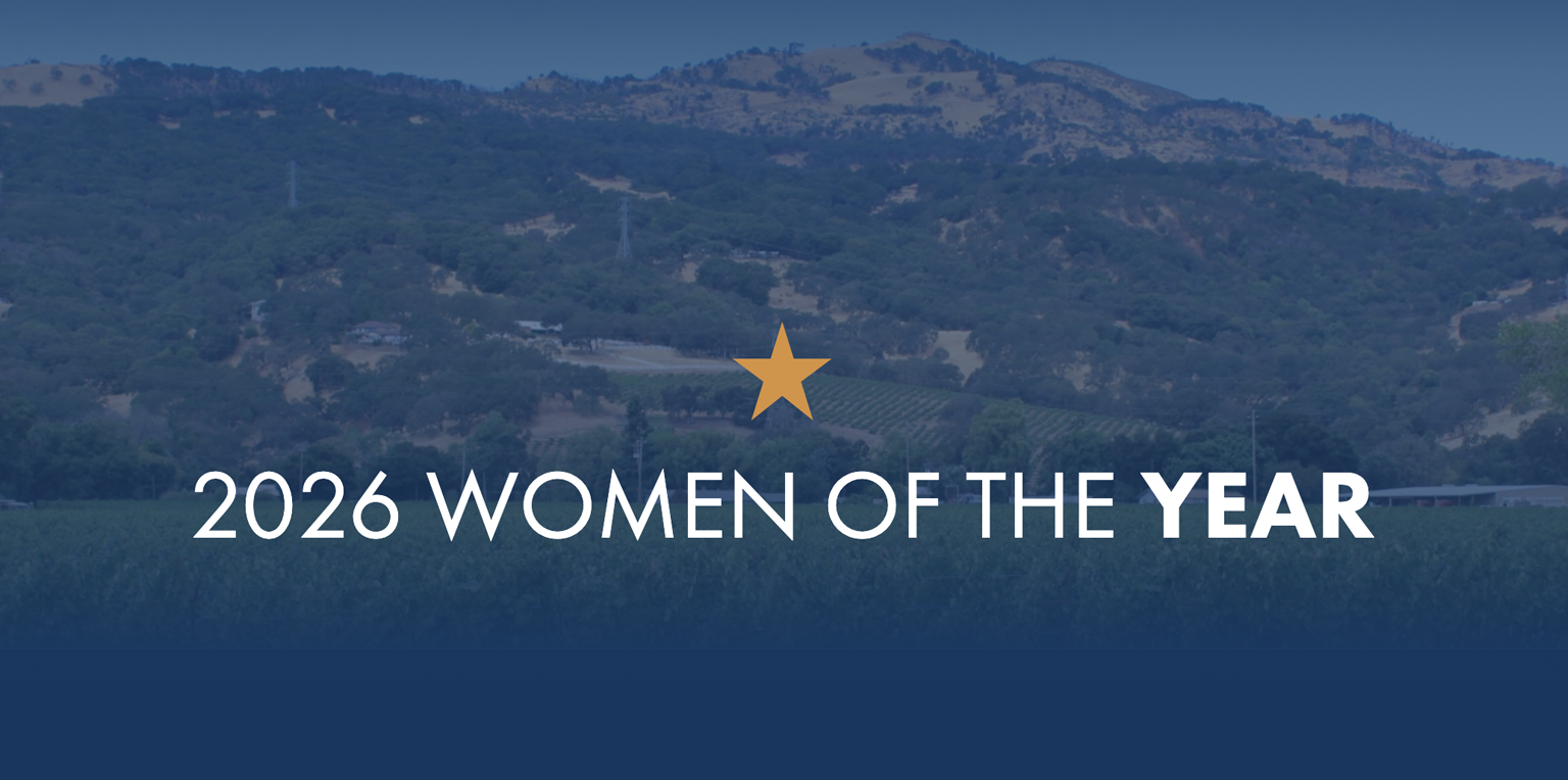 Text reading 2026 WOMEN OF THE YEAR with a golden star, set against a background of hills.